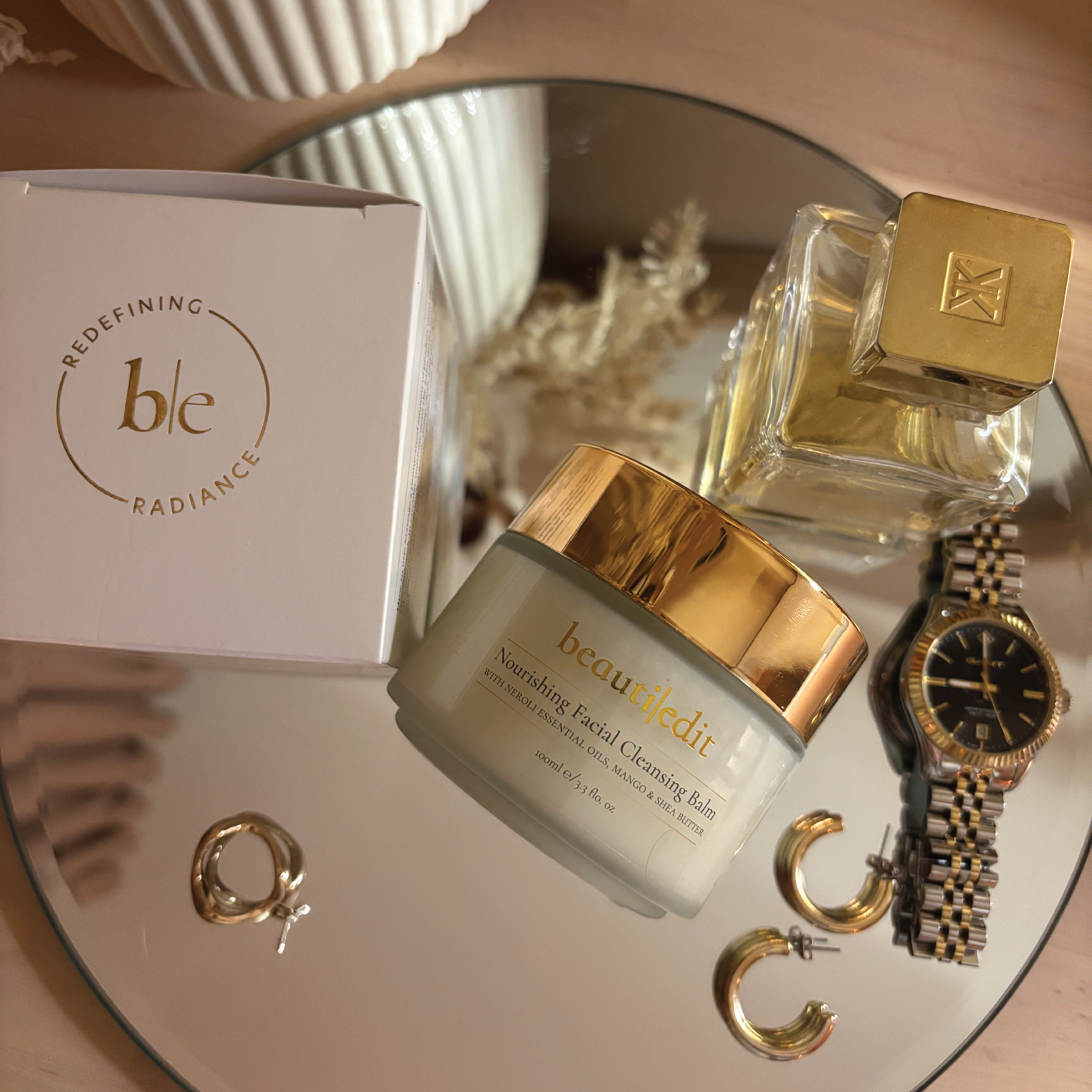 BeautiEdit Facial Cleansing Balm on a mirror next to some scattered jewellery.